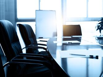 boardroom chairs and table with notebook and pen